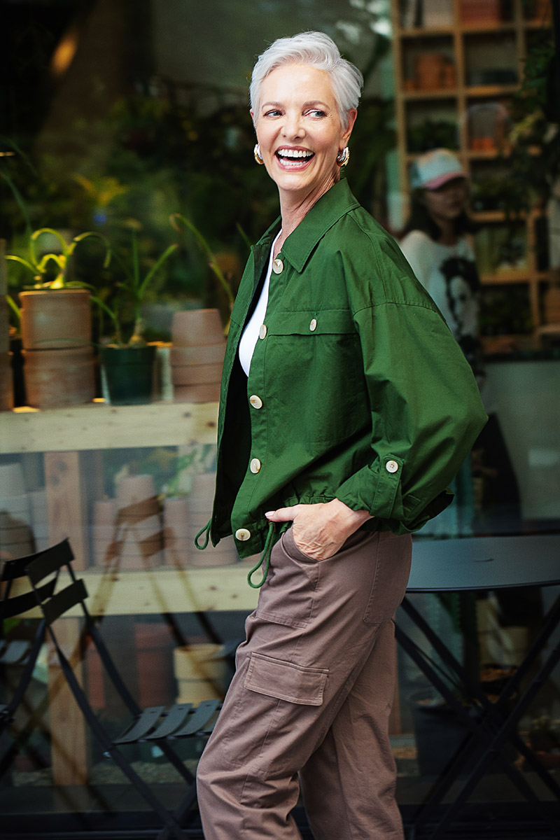 Mature woman wearing olive utility jacket with cream knit